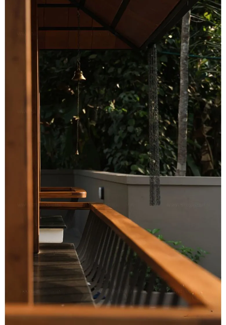 A simple wooden bench stands beside a house, offering a welcoming place to sit and enjoy the surrounding scenery.