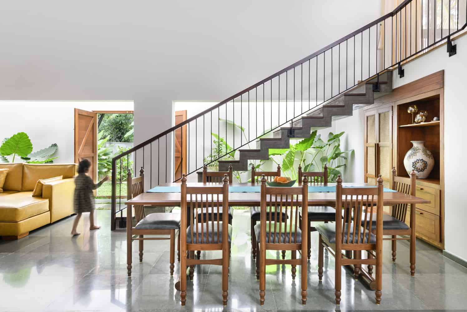 A cozy dining room with a staircase leading to the second floor.