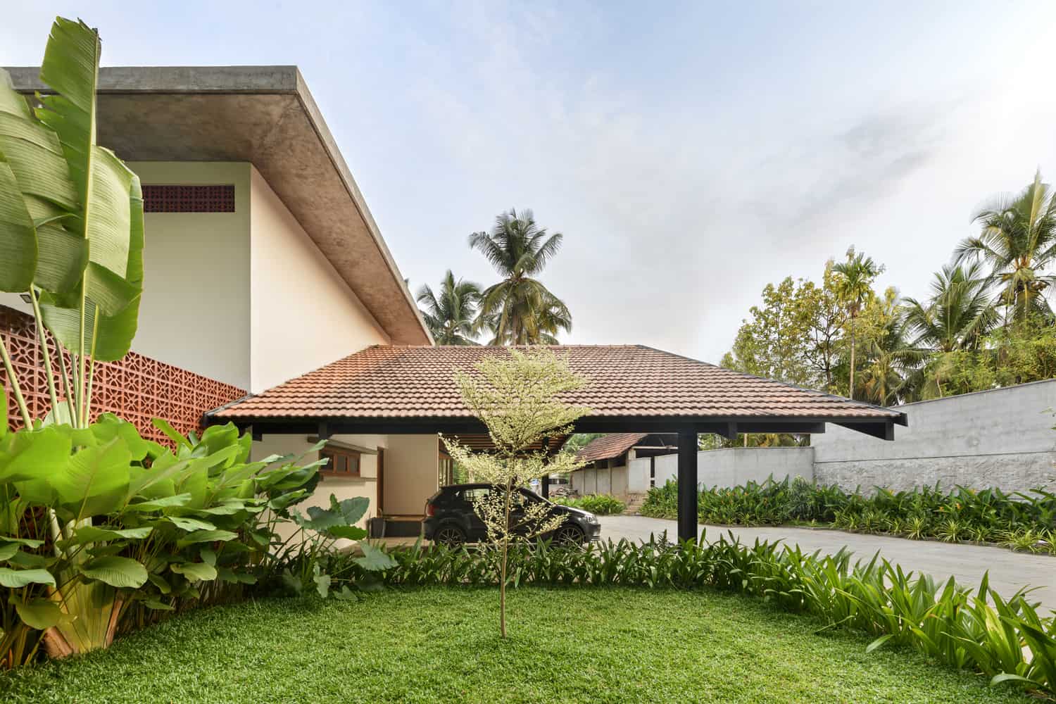 Beautiful modern home with lush green lawn and parked car in driveway.